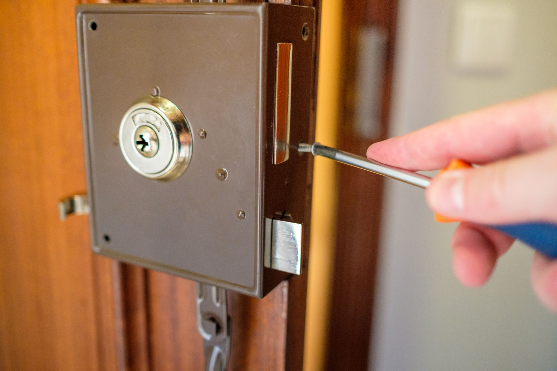 Un homme change une serrure sur la porte de la maison